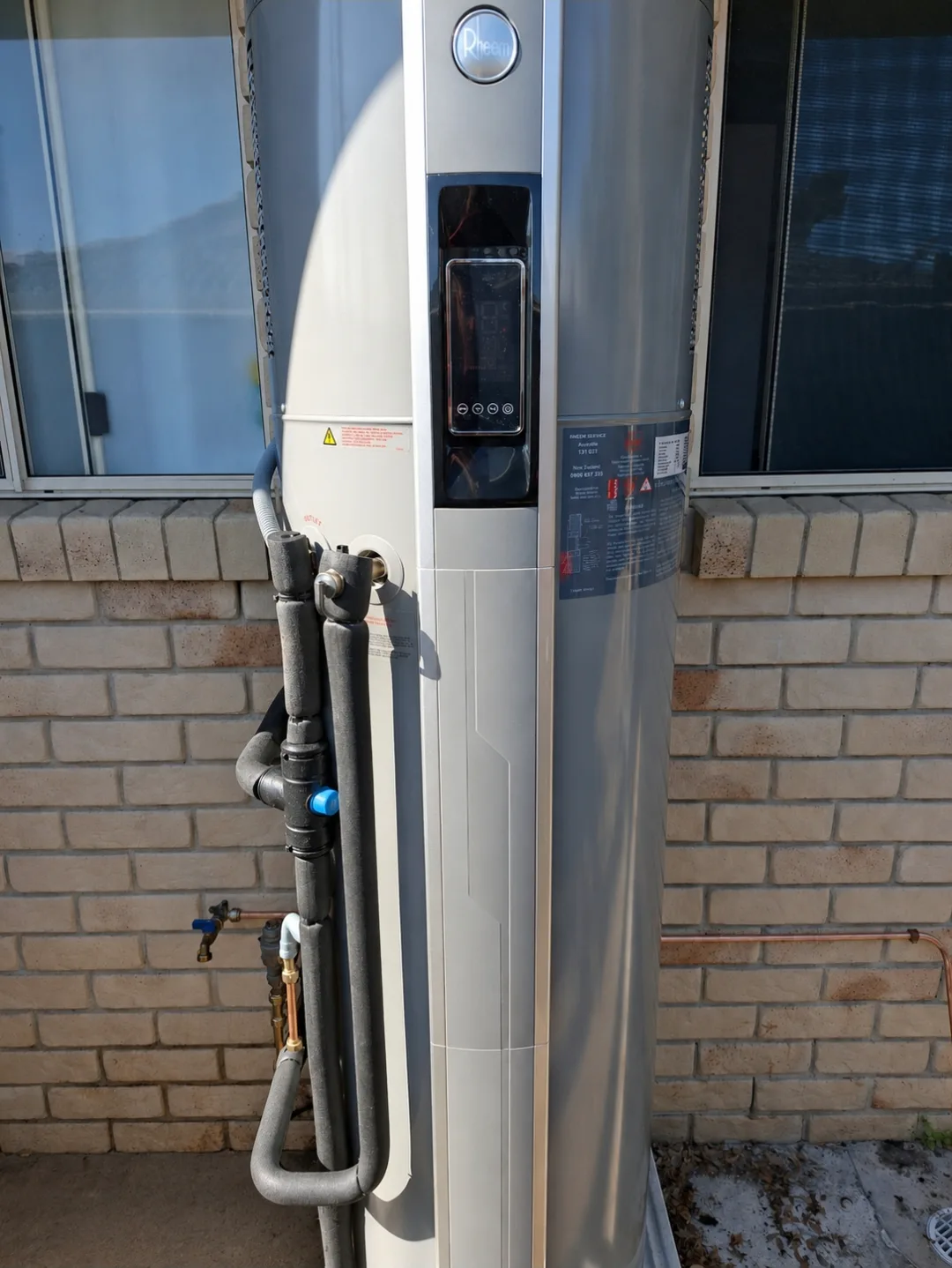 A Rheem heat pump hot water system installed by RCM, controller and lagged pipework visible