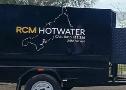 The RCM Hot Water trailer, lettered with the business name and phone number