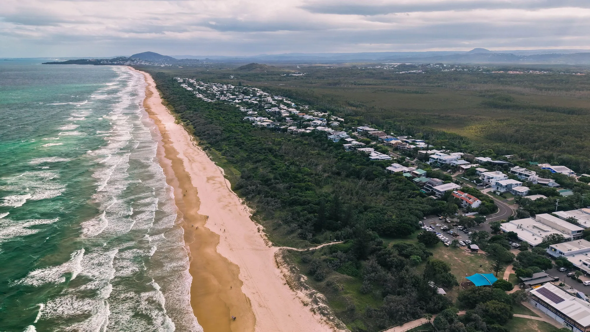 Aerial view of the Sunshine Coast shoreline, with the beach and suburbs stretching north